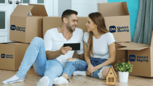 Young couple sitting on floor using tablet computer after moving