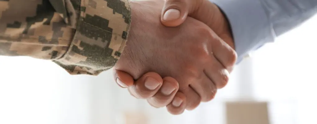 Soldier and businessman shaking hands