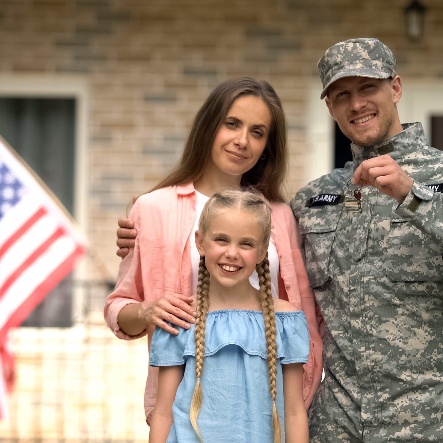 US military man with family showing keys from house